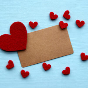 Red hearts and brown card on blue background.